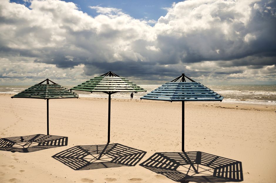 Handgemaakte rieten parasol in zonovergoten tuin.
